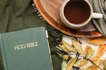 mug on a tray, fall leaves on a green scarf and Holy Bible 