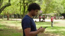 Young latino man holding mobile phone, using online app on smartphone, looking for directions