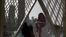 Middle eastern man and woman, married couple in Dubai looking at Burj Khalifa and skyscrapers at Dubai mall.