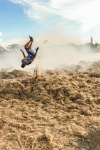 man doing a flip in a burning field in Haiti 