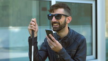 a blind man talking on a cellphone 