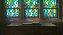 old chapel bible on an altar stained glass dolly-zoom wide angle 