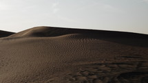 Middle Eastern desert scenery landscape near Duba, United Arab Emirates with sand blowing in the wind in cinematic slow motion.