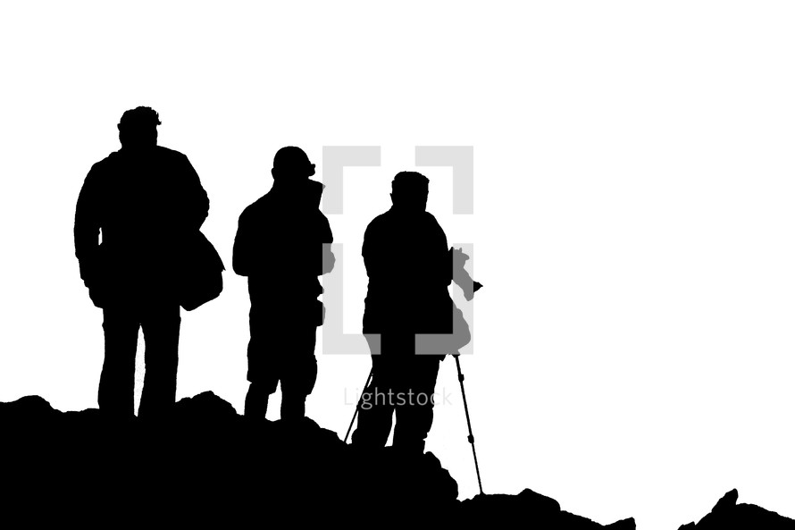 silhouettes of tourists standing in front of a volcano with cameras 