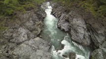 Aerial view of a river running in between rocky shores.