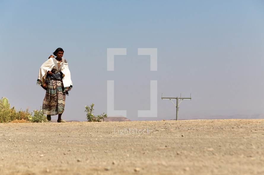 woman walking across a desert 