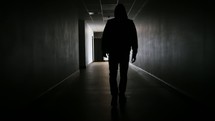 silhouette of a man walking down a hallway 