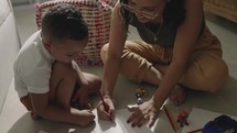 Mother and son drawing on the floor together