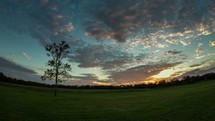 Timelapse of cloud movement and sunset over the countryside.