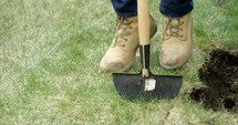 man stomps on lawn edger to break up sod grass - close up on feet - slow motion