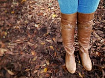 leather boots standing on fall leaves 