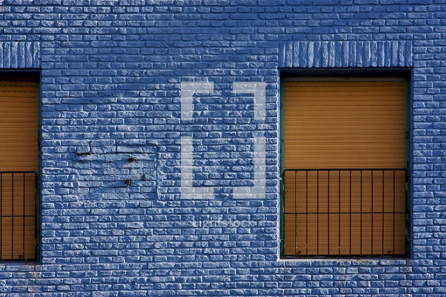 blue brick wall and yellow gates 
