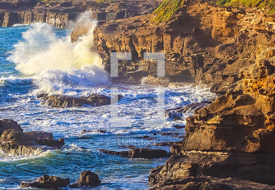 waves crashing into cliffs along a shore 