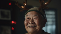 AI Generated Image. Happy Asian senior elderly man wearing Christmas reindeer antlers and having fun at home