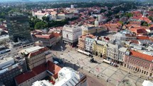 Aerial shot drone orbits to the right around main plaza Trg bana Josipa Jelačića in Zagreb, Croatia