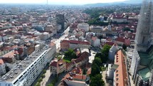 Aerial shot drone flies from left side of Cathedral of Zagreb over main plaza Trg bana Josipa Jelačića in Croatia