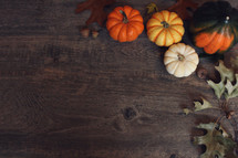 Fall Thanksgiving Holiday Background with Pumpkins, Leaves and Squash Over Wood