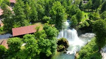 Aerial shot drone orbits to the left around large waterfall in Rastoke, Slunj, Croatia