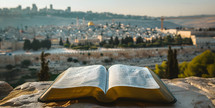 Bible open looking out towards Jerusalem, Israel from the viewpoint of Mount of Olives