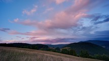 
Colorful clouds at sunset over the hilly and forest landscape in the Carpathian hills timelapse
