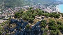Aerial shot drone orbits to the left around the castle on top of La Rocca in Cefalu, Sicily, Italy