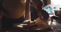 Pregnant woman cutting and stacking pieces of bread of childs lunch - close up on hands
