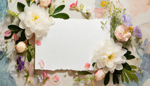 dimensional flowers surround a large ragged piece of white deckle edge paper