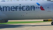 Close up of an American Airlines aircraft moving along an airport taxiway.