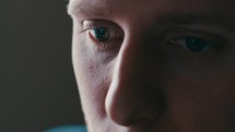 Extreme close up of a man's eyes as he works on a computer.