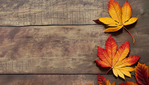 a few autumn leaves along one side of a flat lay composition on wood boards with copy space
