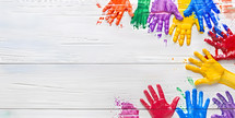 children's painted hands and hand prints on a white wooden background