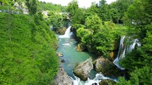 Aerial shot drone flies low along river with waterfalls in Rastoke, Slunj, Croatia