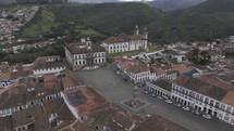 Drone orbits to the left in a medium shot around Praça Tiradentes in Ouro Preto on a cloudy day