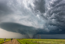 Storm Chasers Photographing A Tornado Under A Spectacular Supercell StormAlong A Dirt Road In Montana