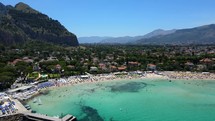 Aerial shot drone flies from water toward south side of Mondello Beach in Palermo, Sicily, Italy