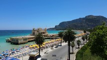 Aerial shot drone flies up and away from boardwalk at Mondello Beach in Palermo, Sicily, Italy