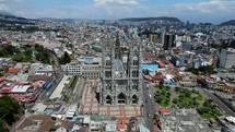 Aerial shot drone flies toward Quito basilica that looks like Notre Dame in Paris