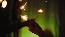 Silhouette of hands waving sparkles for new year event party