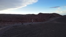 Aerial shot drone flies up and away from viewpoint overlooking San Pedro de Atacama and the red rocks of Death Valley