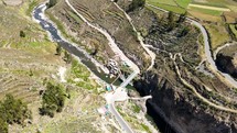 Aerial shot drone flies forward as camera pans down over bridge crossing Calera thermal baths