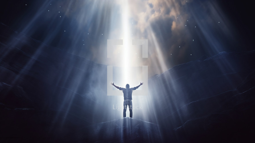 Man with arms to the sky illuminated by a beam of heavenly light