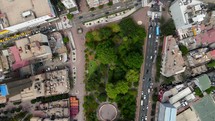 Aerial shot drone flies backwards with camera straight down over full length of central park in downtown area with skyscrapers