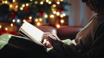 Old Man Reading A Book On Christmas seated on the sofa of his house.