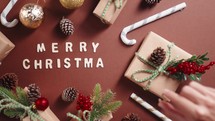 Merry Christmas text on brown table with gift boxes