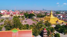 Aerial Vientiane Laos Capitol Buddhism Temple Palace Tropical Palm Trees City Urban Flying View Drone Footage 4K