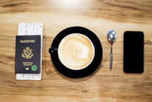 passport, cellphone, plane ticket, and coffee cup 