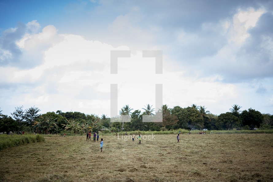 village children playing in a field 