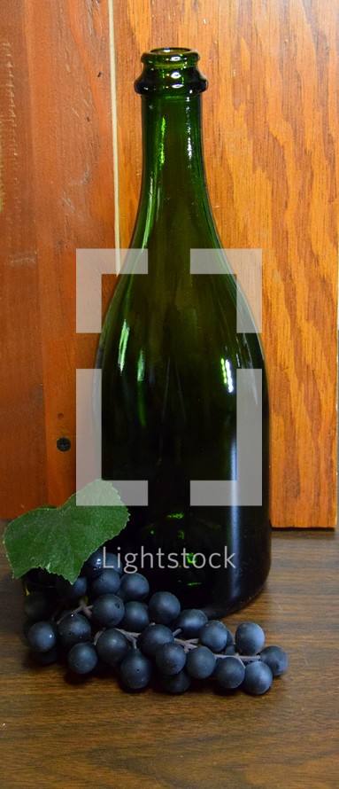 Wine bottle with bunch of grapes