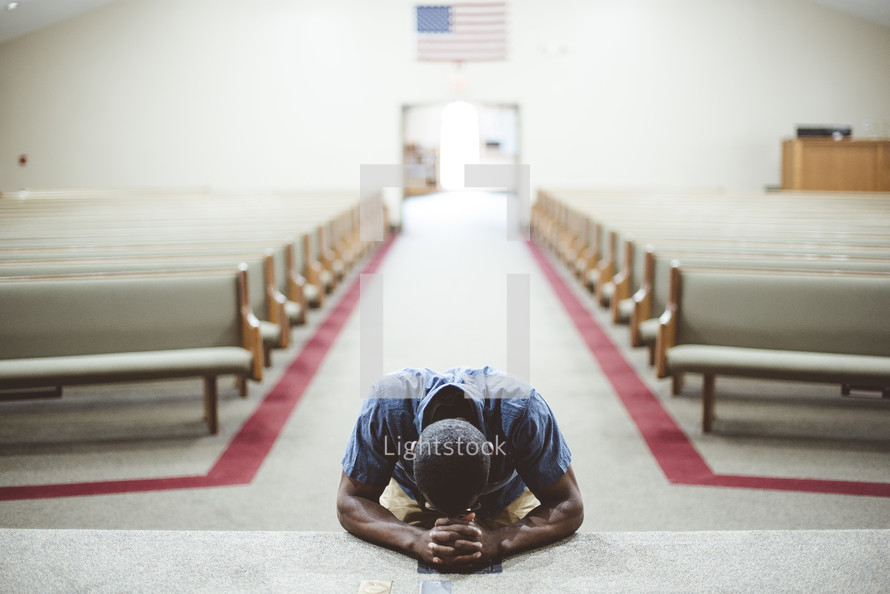 a man kneeling in prayer at an altar 