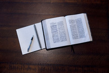 notebook, pen, and opened Bible 